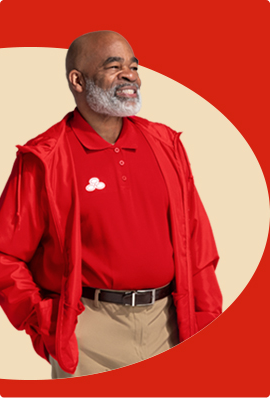 A bearded State Farm agent in red polo and pullover smiles.